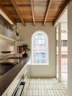 a kitchen with an arched window and tiled floor