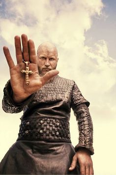 a black and white photo of a man with his hand up to the cross on his palm