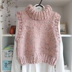 a pink sweater hanging on a clothes rack