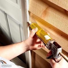 a person holding a paint roller in their hand and painting the inside of a door