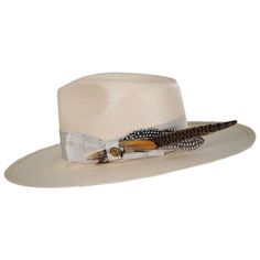 The stylish wide brim Atacama brings a modern appeal to a classic style. The oversized feathers on the hat are just one of its unique features. 4" Flat Brim and 5" Teardrop Crown All Natural Shantung Straw Firm Finish Made in the USA Beach Hats With Feathers And Wide Brim, Wide Brim Beach Hat With Feathers, Feathered Hat Bands For Beach With Curved Brim, Feathered Hat Bands With Curved Brim For The Beach, Elegant Fedora With Feather Trim, Curved Brim Fedora With Feather Trim For Kentucky Derby, Wide Brim Fedora With Feathers For Kentucky Derby, Western Summer Hats With Feathers, Western Summer Hat With Feathers