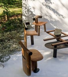 four wooden chairs and tables in the snow