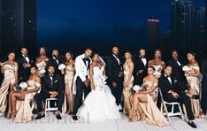 a group of people in formal wear posing for a photo on a rooftop at night