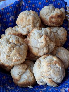 a basket filled with muffins sitting on top of a blue and white cloth