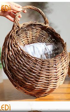 a person holding a wicker basket on top of a wooden table