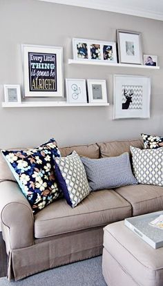 a living room filled with lots of furniture and pictures on the wall above it's coffee table