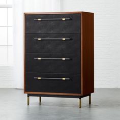 a black and brown chest of drawers with brass handles