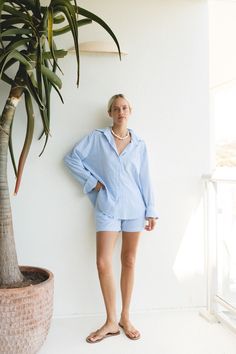 The Océan Blue Cotton Striped Shorts Set features a button-up top and high-waisted shorts crafted from soft, breathable cotton fabric with a subtle pin stripe pattern. Blue Cotton Button-up Shorts, Blue Shorts For Spring Daywear, Blue Button-up Cotton Shorts, Cotton Button-up Shorts For Day Out, Button-up Cotton Shorts For Day Out, Spring Button-up Shorts For Daywear, Relaxed Blue Cotton Shorts, Chic Blue Relaxed Fit Shorts, Blue High-waisted Shorts For Day