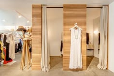 an open closet with clothes on hangers and mannequins in the background