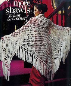 a woman is walking down the stairs wearing a crocheted shawl