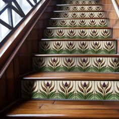 the stairs are decorated with decorative tiles and wooden handrails, along with wood flooring