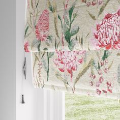 a floral roman blind hanging on the side of a window