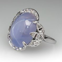 This stunning vintage ring is centered with an oval cabochon cut natural star sapphire set into a six-prong setting. The sapphire is bordered with ten (10), bead set, round brilliant cut diamonds, four (4), semi-bezel set, marquise brilliant cut diamonds and two (2), bezel set, tapered baguette cut diamonds. The ring measures 19.6mm at the top, rises 6.5mm above the finger, tapering to 1.4mm wide and 0.9mm thick at the base of the shank. It is currently a size 6. Luxury Domed Sapphire Ring Fine Jewelry, Luxury Cabochon Sapphire Wedding Ring, Luxury Heirloom Sapphire Open Ring, Fine Jewelry In Platinum With Cabochon, Fine Jewelry White Gold Cabochons For Anniversary, Fine Jewelry Platinum Cabochon, White Gold Fine Jewelry Cabochons For Anniversary, Fine Jewelry Diamond Cabochons For Wedding, Vintage Oval Cabochon Gemstones