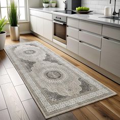 a kitchen area with a rug, sink and counter top in it's center