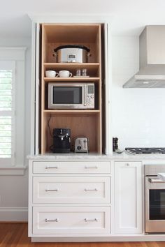 a kitchen with an oven, microwave and toaster on top of the cupboards