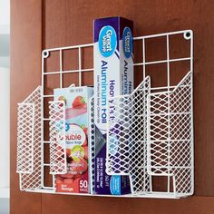 two toothpaste tubes are in a metal basket on the door handle, and another tube is next to it