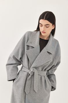 A heavy weight longline rode coat. An oversize fit with long voluminous sleeves and side pockets. Features a lapel collar with an embroidered logo. Comes with a detachable waist belt. A cozy worm coat you can wear over any outfit. 100% Polyester Color: Light grey Care: Dry clean only Oversize fit, take your usual size. Model wears: M Model's fit:1.75 cm Waist 59 cm Hips 86 cm Bust 78 cm How to measure yourself Model Fits, Sweaters Knitwear, Lapel Collar, Waist Belt, Skirt Pants, Heavy Weight, Oversized Fits, Shirt Jacket, Tank Shirt