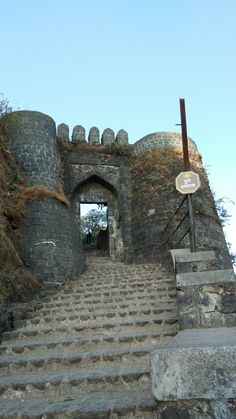 stairs lead up to an old castle like structure with a sign on the top and bottom