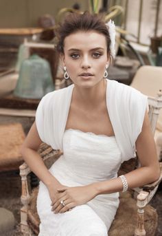 a woman in a white dress sitting on a chair