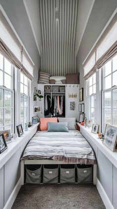 a bed sitting in the middle of a bedroom next to two windows with pictures on them