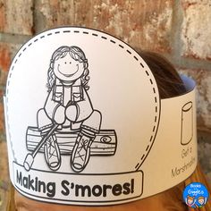 a child wearing a paper hat with the words making s'mores on it