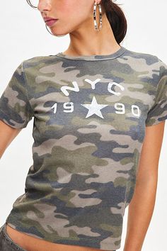 '90s baby tee vibes with this soft and stretchy cropped top complete with NYC graphic at the chest. Only at Urban Outfitters. Features NYC 1990 graphic baby tee Soft and stretchy baby tee Camo print tee NYC graphic at the chest Bodycon fit Cropped length UO exclusive Content + Care 100% Cotton Machine wash Imported Size + Fit Model in Green Multi is 5’10.5" and wearing size Medium Measurements taken from size Medium Chest: 28" Length: 21" | NYC 1990 Graphic Camo Baby Tee in Camo, Women's at Urba Vintage Urban Outfitters Graphic Top, Urban Outfitters Vintage Graphic Print Top, Urban Outfitters Text Print Crew Neck Top, Urban Outfitters Crew Neck Top With Text Print, Vintage Graphic Print Top From Urban Outfitters, Vintage Graphic Print Tops Urban Outfitters, Fitted Graphic Tee From Urban Outfitters, Urban Outfitters Retro Graphic Print T-shirt, Urban Outfitters Retro Graphic T-shirt