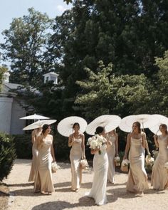 the bridesmaids are holding umbrellas over their heads and walking down the path