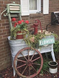 an old fashioned flower cart with flowers in it