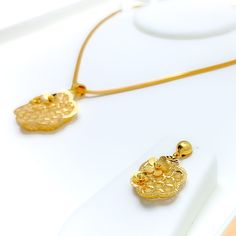 Experience the epitome of luxury with our Ritzy Floral 22K Gold Pendant Set. Crafted from 22k yellow gold, weighing an exquisite 10.1 grams, this set embodies unparalleled elegance. The pendant, measuring 1.5" in length, is complemented by matching earrings, 1.2" in length, featuring convenient push back posts. Embrace the allure of this 3-piece set, chain not included. PRODUCT DETAILS Gold Purity(karat): 22k Gold Weight(grams): 10.1 Item Finish: Yellow Gold Pendant Length: 1.5" Matching Earring Elegant Ceremonial Jewelry Sets With Matching Earrings, Formal Hallmarked Yellow Gold Jewelry Sets, Gold Earrings With Detachable Pendant As Gift, Elegant Gold Jewelry Sets With Detachable Pendant, Luxury Gold Jewelry Sets For Celebration, Elegant 22k Gold Jewelry Sets For Ceremonial, Luxury Gold Plated Yellow Gold Jewelry Sets, Luxury Yellow Gold Plated Jewelry Sets, Yellow Gold 22k Jewelry Sets For Gift