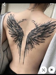 the back of a woman's body with black wings on it