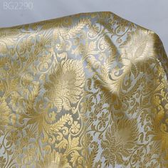 gold and silver brocaded fabric on white background