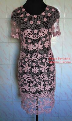 a black and pink dress is on a mannequin head stand in front of a tiled wall