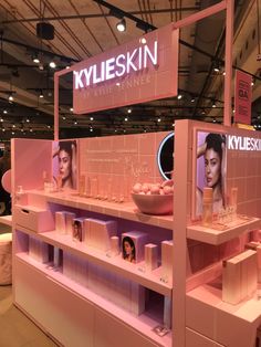 a display in a store filled with lots of beauty products and cosmetics on pink shelves