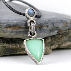 Handmade .999 fine silver necklace with a beautiful green chrysoprase and flashy blue labradorite cabochon. Pendant measures 2.3cm wide by 6.8cm long.  Chrysoprase gemstone measures 1.9cm by 3cm. Blue labradorite measures 0.8cm by 0.9cm. Comes on 3mm round leather cord. Includes gift box. I offer a few different cord lengths. The cord is 3mm round braided leather with sterling silver tube ends and clasp.  Handmade by Mike Summers. We are husband and wife Mike and Annie, making silver jewelry in two uniquely different styles. With a passion for rocks and gemstones, we also cut and polish our own cabochons to use in our creations. We live and work in a tiny cabin in a remote part of Talkeetna in Alaska and it's always a bit of an adventure crossing our creek in a boat to get on the roads to Unique Jewelry With Natural Stones And Chrysoprase, Unique Chrysoprase Jewelry With Natural Stones, Green Moonstone Jewelry With Natural Stones, Unique Green Cabochon Necklace, Green Moonstone Jewelry For Healing, One-of-a-kind Green Chrysoprase Necklace, Unique Chrysoprase Gemstone Necklace, Green Moonstone Jewelry Gift, Silver Jade Cabochon Necklace