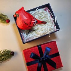 a red bird sitting on top of a gift box