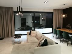 a living room filled with furniture next to a dining table and sliding glass doors that look out onto the patio