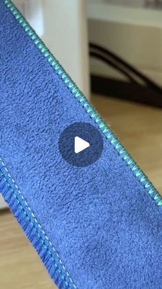 a close up of a blue towel with a video button on it