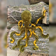 an octopus made out of crochet sitting on top of a piece of wood