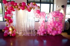 the balloon arch is decorated with pink and gold balloons