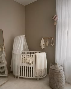 a baby's room with a crib, mirror and other items in it