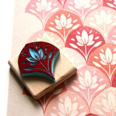 a rubber stamp with a red leaf on it sitting on top of a piece of paper