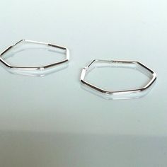 These are minimalist and hexagon shaped sterling silver hoops. Dimensions: 2mm X 25mm Weight: 2.8 gm Price listed is for a PAIR of hoops. These earrings are made of 925 hypoallergenic sterling silver and comes with a 925 stamp. Can be packaged in a gift box. I can include a personal message from you if needed You are welcome to contact me at... bhavnakwintra1956@gmail.com For more beautiful pieces from my shop, please browse 👇 TOE RINGS: https://www.etsy.com/your/shops/TheSilverGame/tools/listi Minimalist Octagon Jewelry For Everyday, Minimalist Everyday Octagon Jewelry, Modern Octagon Hoop Earrings For Gift, Modern Octagon Hoop Earrings As Gift, Modern Octagon Hoop Earrings, Minimalist Geometric Hoop Earrings With Ear Wire, Minimalist Hexagon Hoop Earrings For Gifts, Minimalist Hexagon Hoop Earrings Gift, Hoops Silver