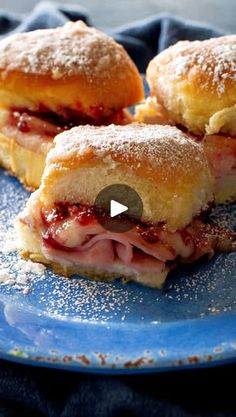 two pastries sitting on top of a blue plate with powdered sugar around them