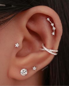 a woman's ear with three different piercings