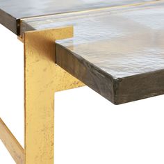 a close up of a metal and wood table with gold trimming on the edge