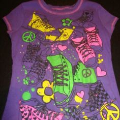 New Without Tags Is A Cute Top By Beautees In A Girls Size Large 10/12 It Is Purple With Little Cap Sleeves With Pink Threading. On The Front Are Yellow, Green And Pink Sneakers With Silver Glitter Laces. There Are Peace Signs, Flowers And Hearts Scattered Around. The Material Is A Very Soft 100% Cotton Cute Multicolor T-shirt For Playwear, Multicolor Spring T-shirt For Playwear, Purple Cartoon Print Tops For Spring, Fun Multicolor Tops For School, Multicolor Graphic Print Tops For Playwear, Fitted Multicolor Tops For School, Multicolor Playful T-shirt For Playwear, Playful Multicolor T-shirt For Playwear, Multicolor Cartoon Print Tops For School