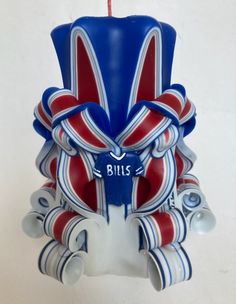 a blue candle with red, white and blue decorations hanging from it's side