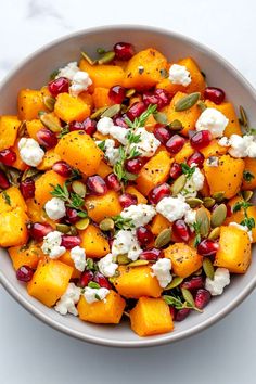 a white bowl filled with pomegranate and feta cheese