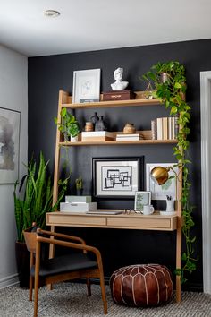 a home office with plants and pictures on the wall