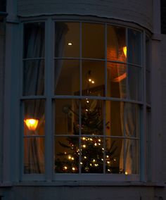 a christmas tree is lit up in the window